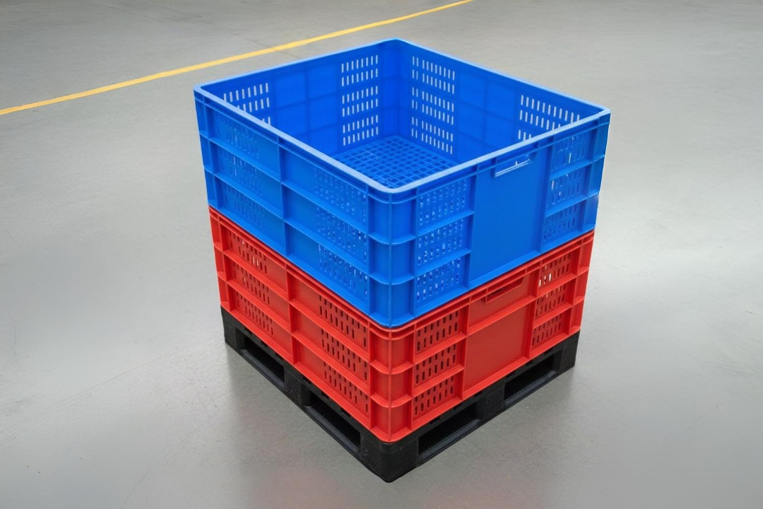 Stacked plastic storage crates in blue and red on a black pallet, placed on a warehouse floor